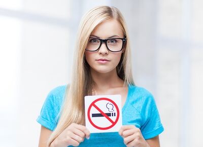 girl holding a sign ban on smoking in the entrance